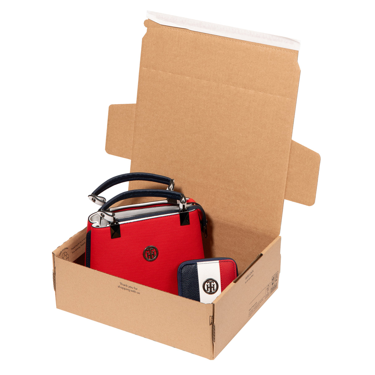 An open SP343+ mailbox packaging with a handbag and purse stored in the box. This box is mainly used for ecommerce packaging. Image shows the Lil Packaging unique 'peel 'n' seal' sealing strip. Manufactured in the UK by Lil Packaging