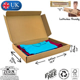 A flat-packed, brown cardboard postal box with dimensions labelled as 34x15x3.5cm . The box is marked as made by Lil, UK, with a small parcel icon, and includes a label indicating it is plastic-free and made from recycled materials. Showing folded cloths packed inside.