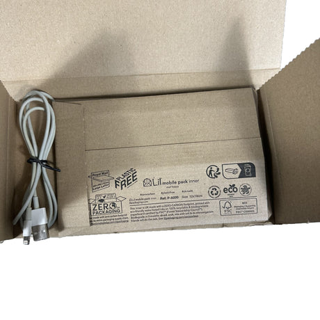 Open cardboard box with a white cable inside, featuring eco-friendly packaging labels.